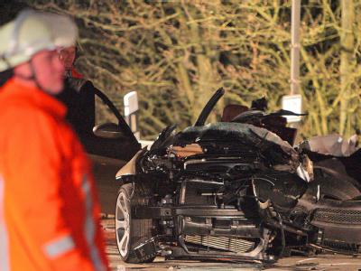 Feuerwehrmänner neben einem verunglückten Pkw. (Archiv- und Symbolbild) Unfall
