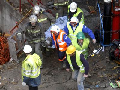 Rettungskräfte bringen ein Opfer des Tunneleinsturzes vom Unglücksort. Tote bei Tunneleinsturz
