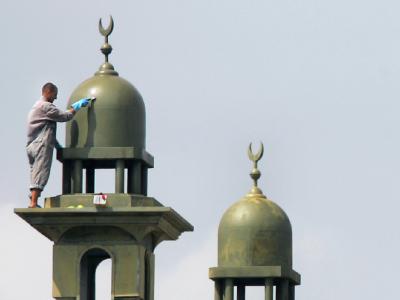 Ein Arbeiter putzt ein Minarett am Neubau einer Moschee. (Archivbild) Moschee-Neubau