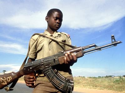 Ein Kindersoldat posiert in Uganda mit seiner Waffe (Symbol- und Archivfoto). Der internationale Waffenhandel soll stärker reglementiert werden. Kindersoldat
