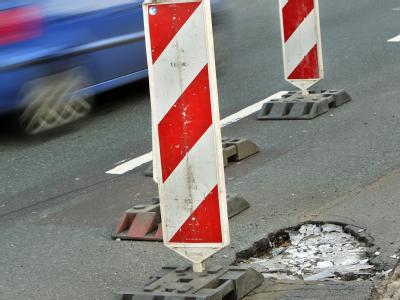 Ein mit Warnbaken abgesperrtes Schlagloch auf dem Ring der Stadt Leipzig. Schlagloch