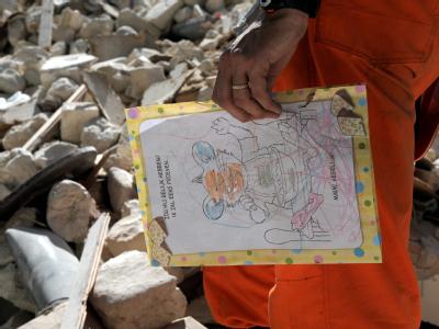 Ein niederländischer Helfer mit einer in den Trümmerbergen von Port-au-Prince gefundenen Kinderzeichnung. Kinderzeichnung