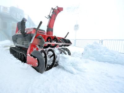 Mit einer Schneefräse geht es der weißen Pracht im höchsten Biergarten Deutschlands an den Kragen. Schnee auf der Zugspitze
