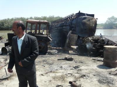 Ein Afghane vor einem der am Freitag bei dem Luftangriff explodierten Tankwagen. Explosionsort