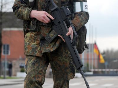 Ein Soldat der Bundeswehr vor dem Haupttor einer Kaserne. Kasernen-Eingang