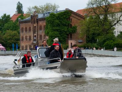 Brandenburgs Ministerpräsident Matthias Platzeck (vorn, l.) schaut sich das Hochwasser vom Boot aus an. Platzeck vor Ort