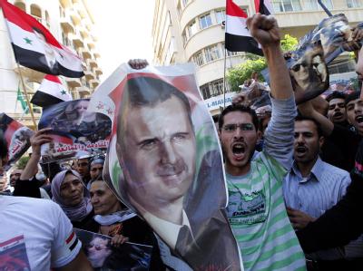 Anhänger des Regimes in Damaskus mit einem Bild von Präsident Assad. Foto: Nabil Mounzer Pro-Assad-Demo