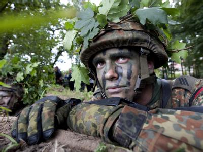 Ein getarnter Soldat auf einem Übungsplatz. Führen Bundeswehr-Reform und Sparmaßnahmen zu Gefahren für die nationale Sicherheit? Soldat