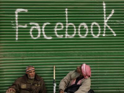 Irritiert betrachtet ein älterer Ägypter den Schriftzug 'Facebook'