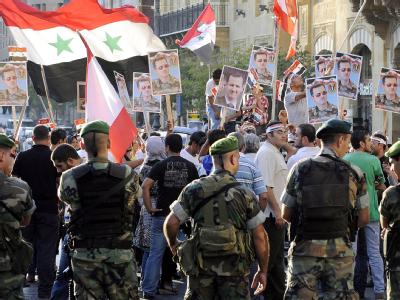 Polizisten und Assad-Anhänger bei einer Demo in Beirut. Zur libanesischen Regierung gehört die mit Damaskus kooperierende Hisbollah-Bewegung. Foto: Wael Hamzeh Beirut
