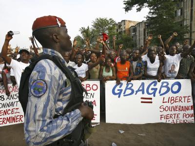 Ein ivorischer Polizist beobachtet eine Pro-Gbagbo-Demonstration in Abidjan. Gespannte Stimmung