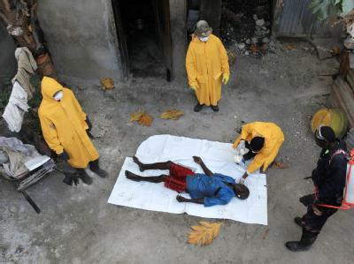 Mitarbeiter der Gesundheitsbehörden in Haiti neben einem Opfer der Cholera in Port-au-Prince. Cholera in Haiti
