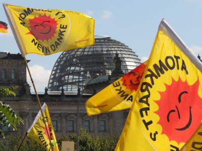Fahnen von Atomkraft-Gegnern vor der Kuppel des Reichstagsgebäudes. Anti-AKW-Protest