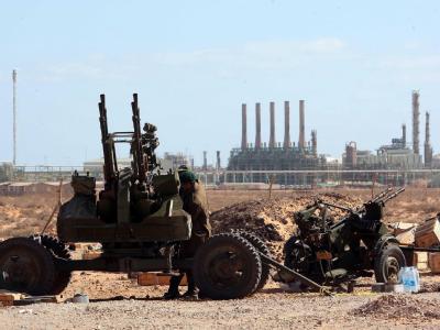 Ein Geschütz der Gaddafi-Gegner vor der Kulisse der Öl-Raffinerie von Ras Lanuf. Rebellen vor Raffinerei