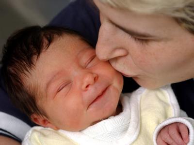 Eine Frau küsst ihr wenige Tage altes Töchterchen. Archivfoto: Patrick Pleul. Nach ihrer Rückkehr aus der Babypause stößt Familienministerin Schröder die Debatte über das umstrittene Betreuungsgeld neu an. Mutter und Kind / Betreuungsgeld