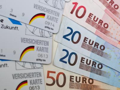 Krankenkassen-Karten und Euro-Scheine: Vielen Versicherten droht eine Pfändung. Krankenkassen-Karten