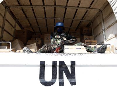 Ein Blauhelm-Soldat bewacht ein Fahrzeug der Vereinten Nationen. UN-Fahrzeug