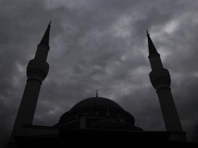 Die Minarette einer Moschee in Berlin ragen in den bewölkten Himmel. Moschee
