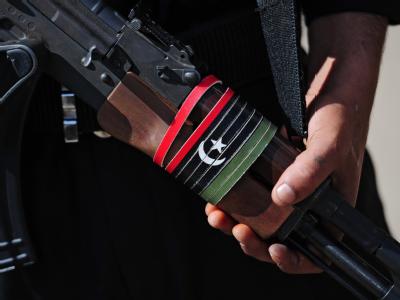 Ein Nachrevolutionsproblem in Libyen: Es sind noch viele Waffen im Umlauf. Foto: Hannibal/ Archiv Kalaschnikow mit libyscher Flagge