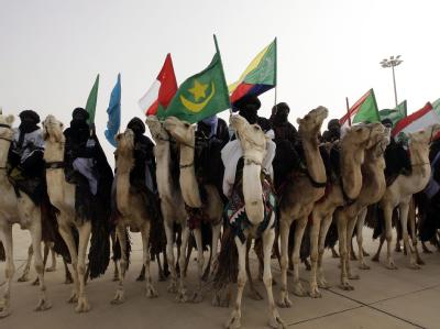 Ausgestattet mit den Fahnen arabischer Länder erwarten Kamelreiter die Gäste des Gipfels Begrüssung