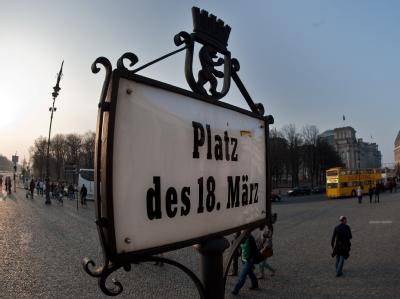 Ein Schild mit der Aufschrift «Platz des 18. März» steht in Berlin auf der Rückseite des Brandenburger Tores. Foto: Robert Schlesinger Platz des 18. März