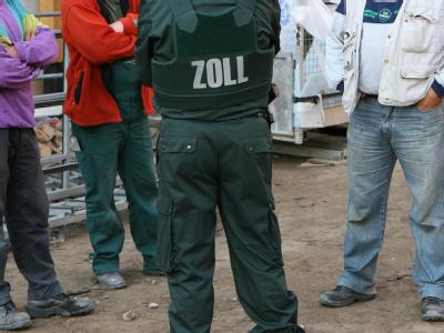 Auf einer Baustelle überprüft ein Zollbeamter Arbeiter auf Schwarzarbeit. (Symbolbild) Kampf gegen Schwarzarbeit