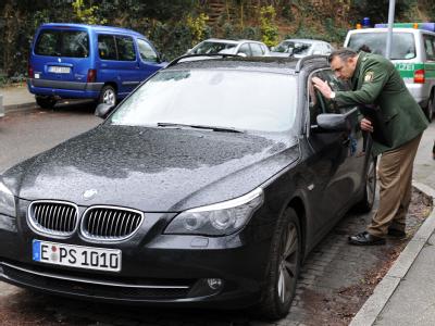 Ein Polizist untersucht das Fluchtfahrzeug der entflohenen Schwerverbrecher am Sonntag (29.11.2009) in Mülheim. Fluchtfahrzeug