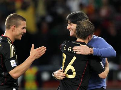 Joachim Löw herzt Philipp Lahm und Lukas Podolski nach dem gewonnenen Viertelfinale zwischen Argentinien and Deutschland in Kapstadt 2010. Löw bleibt Bundestrainer