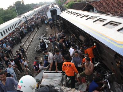 Retter suchen in den Trümmern des in Zentral-Java verunglückten Zugs nach Überlebenden. Zugunglück in Indonesien