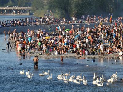Menschenmassen am Strand an der Isar in München: Die Temperaturen bieten einen Vorgeschmack auf den Sommer. Foto: Andreas Gebert Sonnenbad an der Isar
