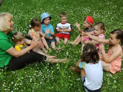 In einem Kindergarten singen Kinder mit der Erzieherin: Das Bundesumweltministerium will Klagen wegen Kinderlärms erschweren. Kindergarten