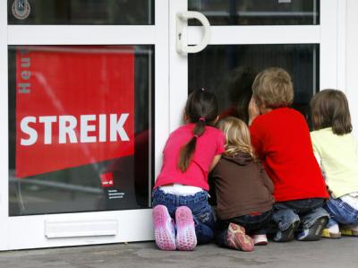 Kinder vor einer bestreikten Kindertagesstätte. Kita geschlossen