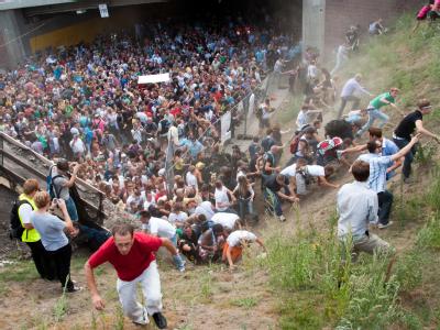 Tausende Raver drängen sich am 24. Juli 2010 in und vor dem Tunnel in Duisburg, in dem sich eine Massenpanik ereignet hat. Die Loveparade-Katastrophe forderte 21 Todesopfer. Auf der Flucht