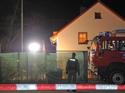 Schock im oberbayerischen Notzing: In der kleinen Ortschaft hat die Polizei in der Nacht zwei Leichen gefunden. Foto: Marc Müller Polizist an der Fundstelle