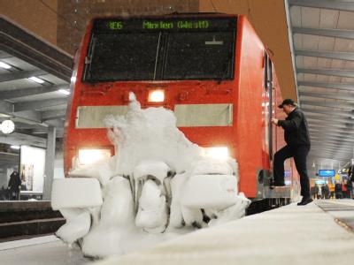 Ein Zugführer steigt am Hauptbahnhof in Essen in einen vereisten Regionalexpress. Verspätungen bei der Bahn