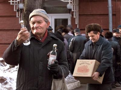 Den Blick auf die Wodka-Flasche gerichtet, verlässt ein älterer Mann den Spirituosen-Laden der Schnapsbrennerei Schnapsverkauf in Moskau