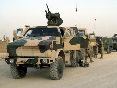 Deutsche Bundeswehrsoldaten warten im Feldlager Kundus neben ihren Militärfahrzeugen auf das Ausrücken ihrer Einheit. Bundeswehr in Kundus