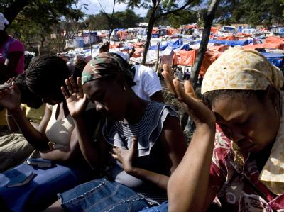 Haitianische Frauen beten in einem Flüchtlingslager. Über eine Million Haitianer sind obdachlos. Gebet im Flüchtlingslager