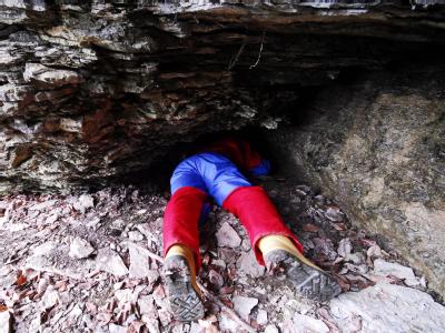 Ein Höhlenforscher kriecht in eine Felsspalte. (Archivbild) Höhlenforscher