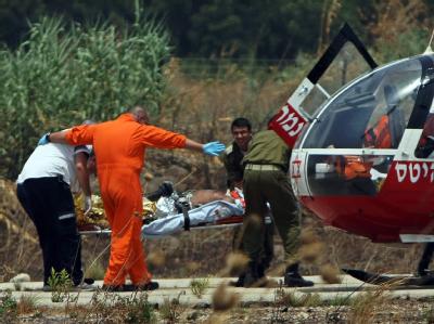 Israelische Sanitäter tragen einen verwundeten israelischen Soldaten in einen Hubschrauber. Israel - Feuergefecht an der Grenze