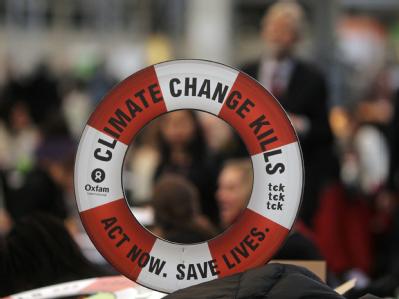 Ein Rettungsring mit aussagekräftiger Aufschrift ist bei der UN-Klimakonferenz im Vordergrund zu sehen. Entscheidende Phase
