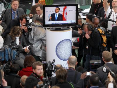 Gipfelteilnehmer und Journalisten schauen die Rede von US-Präsident Barack Obama auf einem Monitor an. Weltklimagipfel