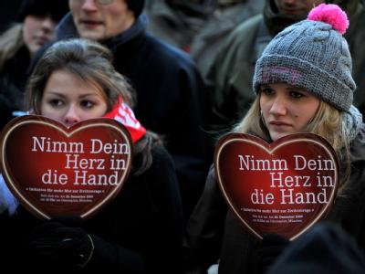 Besucher der Kundgebung der Dominik-Brunner-Stiftung halten Herzen in ihren Händen. Kundgebung für Dominik Brunner