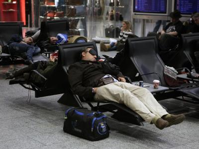 Gestrandete schlafen im Frankfurter Flughafen in einem Wartebereich. Chillout-Lounge