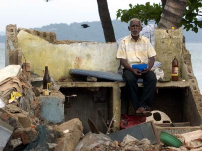 Ein Mann sitzt am 31.12.2004 in den Trümmern seines Hauses in Galle, Sri Lanka. Fassungslos