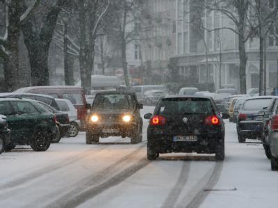 Autos fahren in Hamburg durch eine frisch verschneite Straße. Schneefall in Hamburg