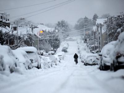 Ein einsamer Radfahrer auf einer verschneiten Straße im englischen Hampshire. Winter in Großbritannien