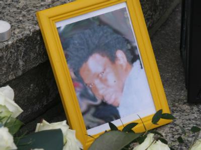Ein Foto und Blumen liegen zum Gedenken an Oury Jalloh vor einer Polizeistation in Dessau-Roßlau. Gedenken