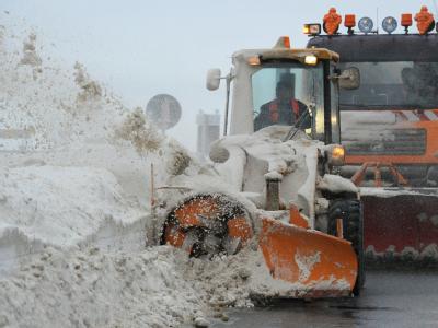 Eine Schneefräse räumt bei Altefähr auf Rügen eine Straße frei. Aufräumarbeiten