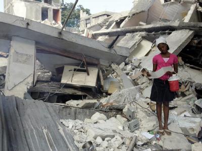 Ein junges Mädchen steht in den Trümmern eines eingestürzten Huses in Port-au-Prince. Mädchen in Trümmern
